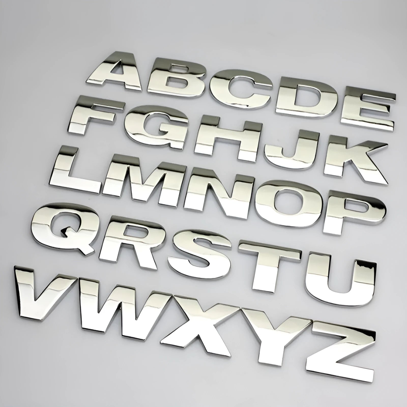 3D metal zinc alloy car letter sticker in black or silver, shown actual size at 2.5cm.
