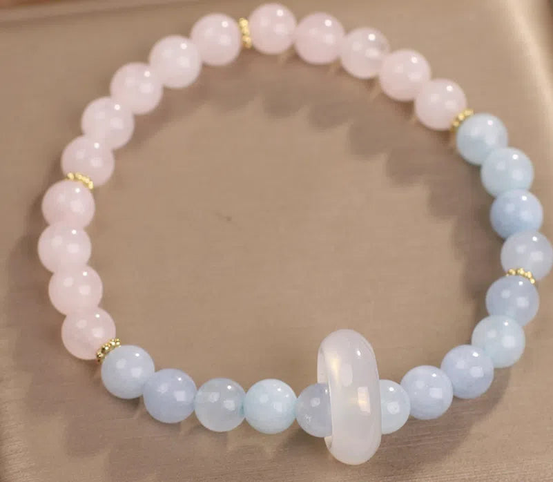 Natural aquamarine crystal beaded bracelet with pink electroplated finish on display