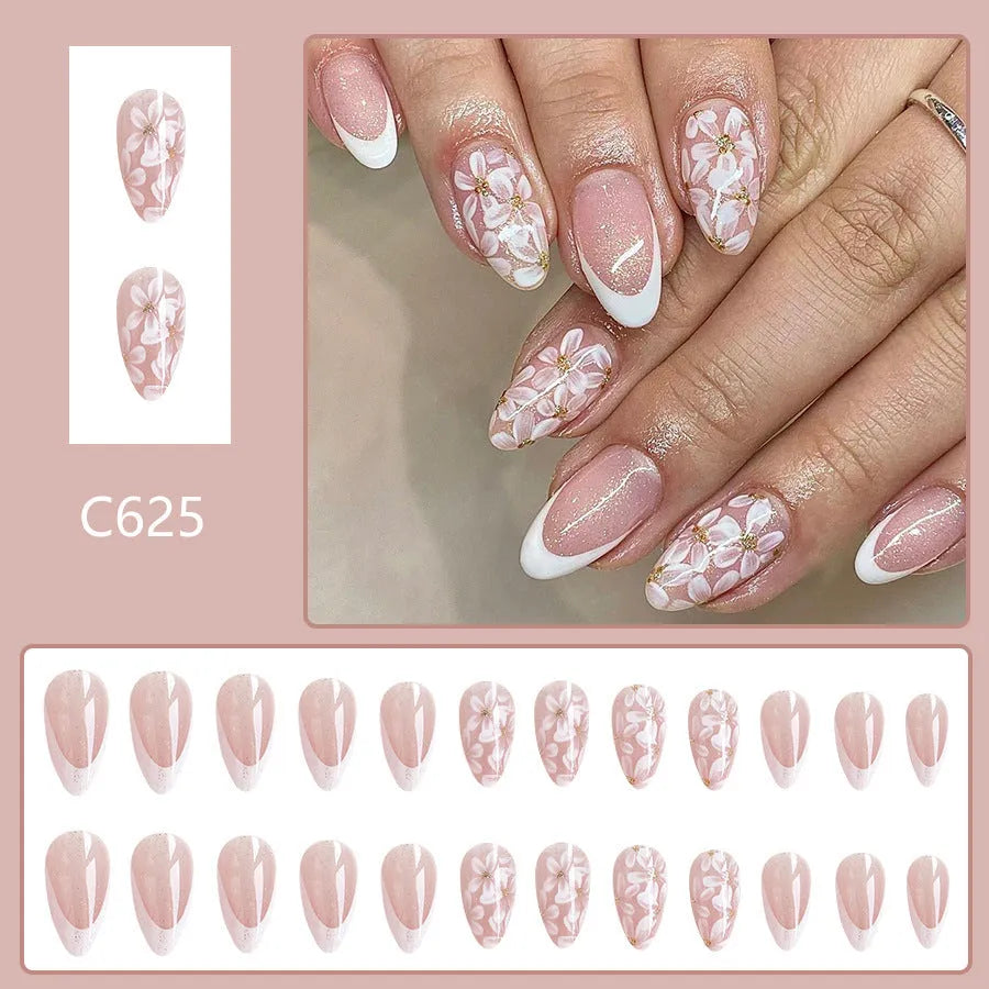 Short almond French style press-on nails with glitter accents and powder flower design on white background