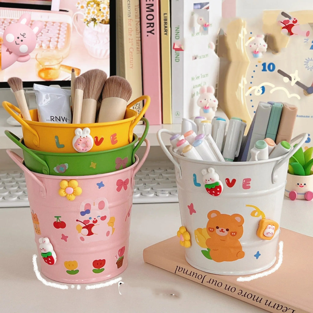 Round creative iron art metal pen holder in assorted colours on a wooden desk.