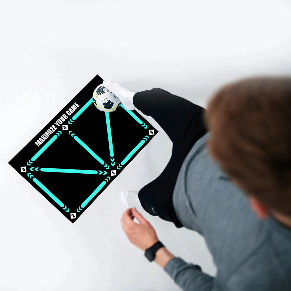 Black rectangular football training mat on grass for skills practice.
