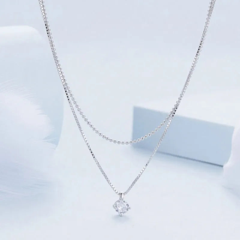 Close-up of a women's double-layer pearl chain necklace in S925 sterling silver with a shining pendant.