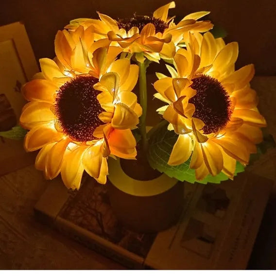 Sunflower LED night light with artificial flowers on wooden table