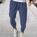 Man wearing loose light-coloured cotton trousers with elasticated ankle cuffs, showing front and side views.