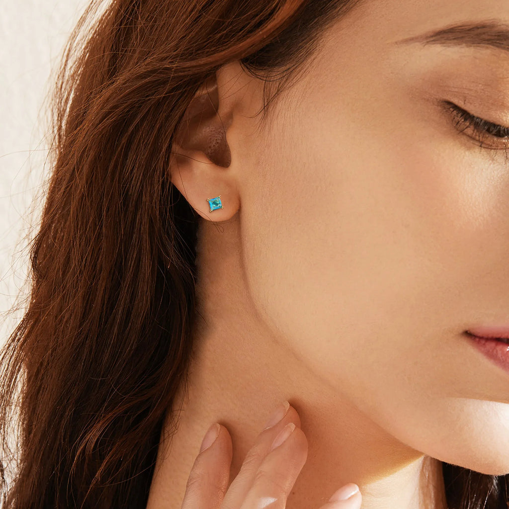 A pair of brass gold-plated drop earrings with a pear-shaped zircon stone, in a candy colour.