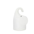 White elephant silicone night light with warm glow on a bedside table.
