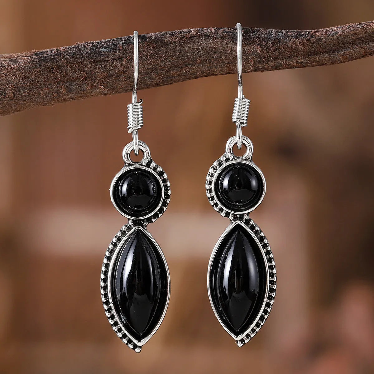 A pair of vintage geometric pendant earrings in black and purple with a Bohemian style.