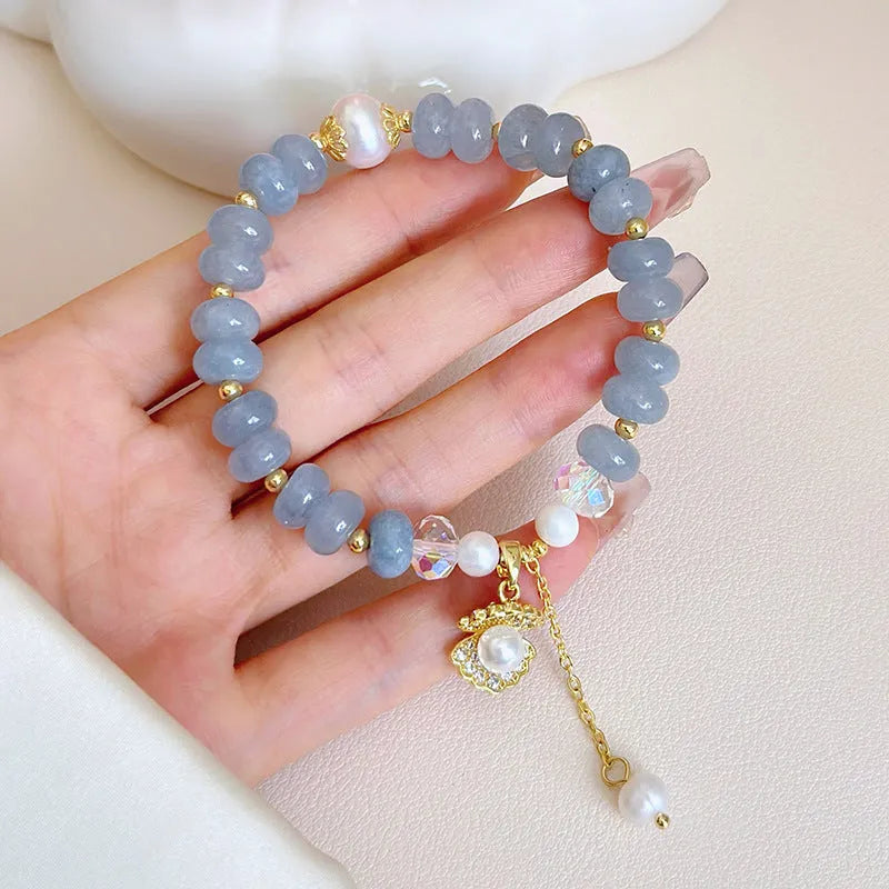 Natural aquamarine pearl shell bracelet on wrist showing adjustable design and handcrafted bead details