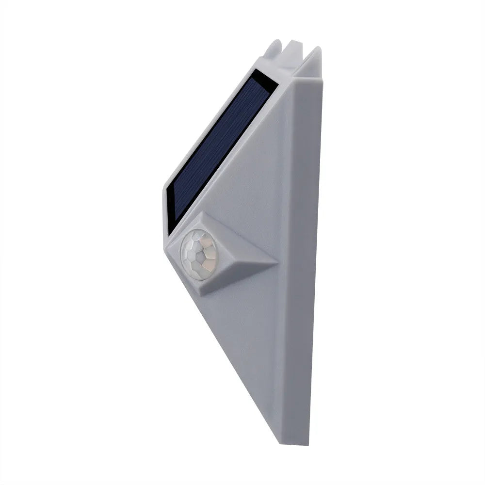 Solar-powered outdoor step light with motion sensor in abstract design on a brick step.