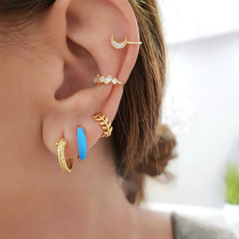 Pair of curved oval epoxy earrings in geometric ring design on a U-shaped hook.