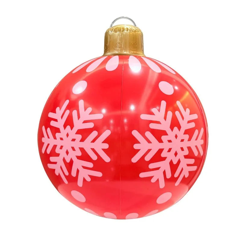 Large red inflatable Christmas ball with flashing lights in garden setting