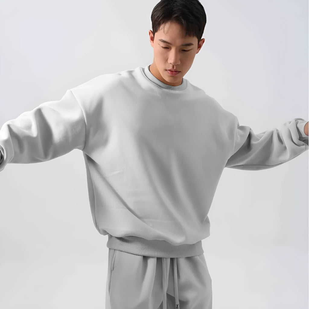 Man wearing a black polar fleece sports suit with a crew neck coat and loose trousers.
