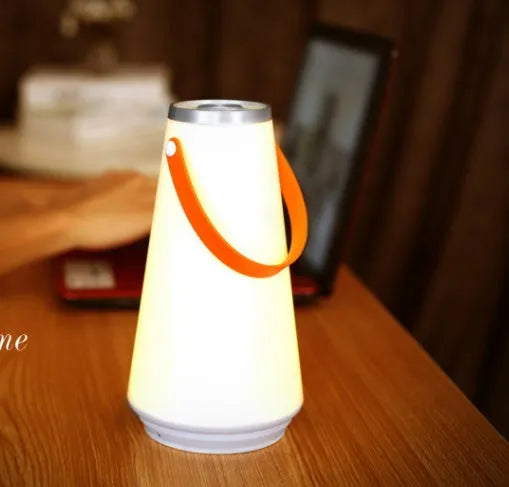White USB rechargeable LED bedside night light with touch control on a wooden table.