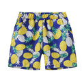Colourful printed beach shorts on a hanger showing coconut tree and dinosaur designs.
