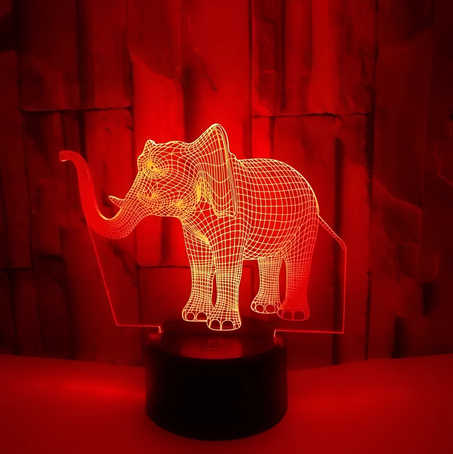 3D LED elephant touch lamp showing seven colour modes on a wooden desk
