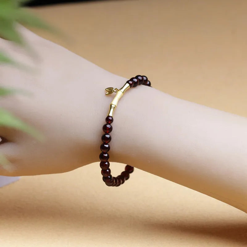 Natural garnet stone set in a 6mm wide bamboo joint bracelet with copper or silver metal finish.