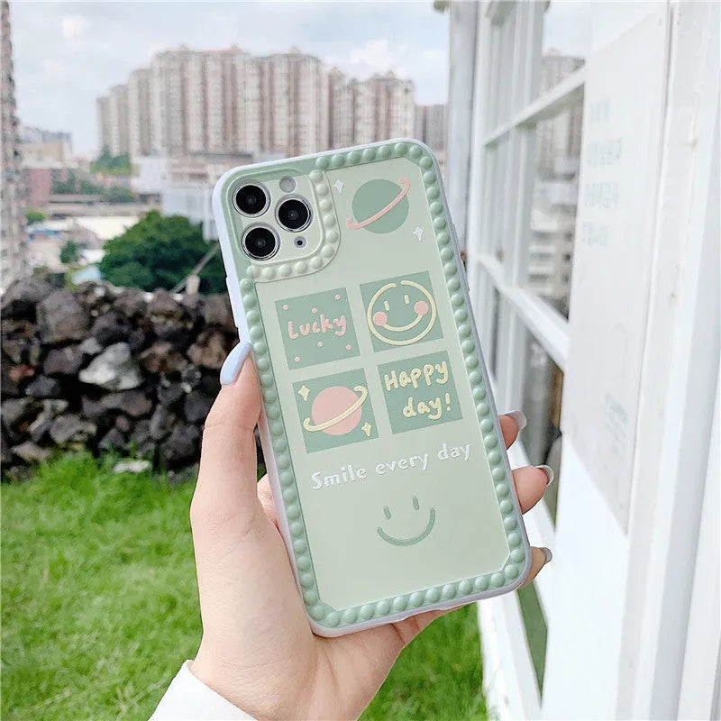 Green iPhone case with geometric smiley face and white polka dot design on a soft rubber TPU back cover.