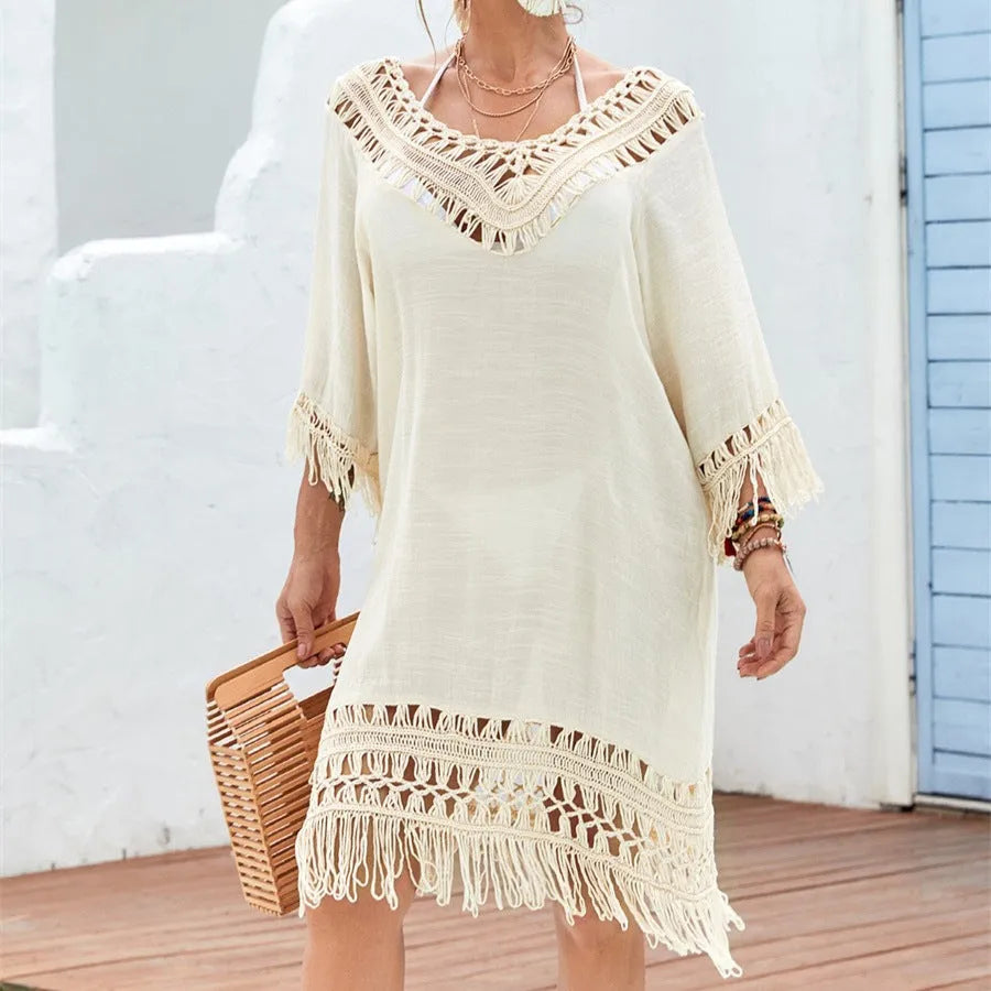 Apricot coloured crocheted patchwork beach dress on a hanger, showing mid-length skirt and half sleeves.