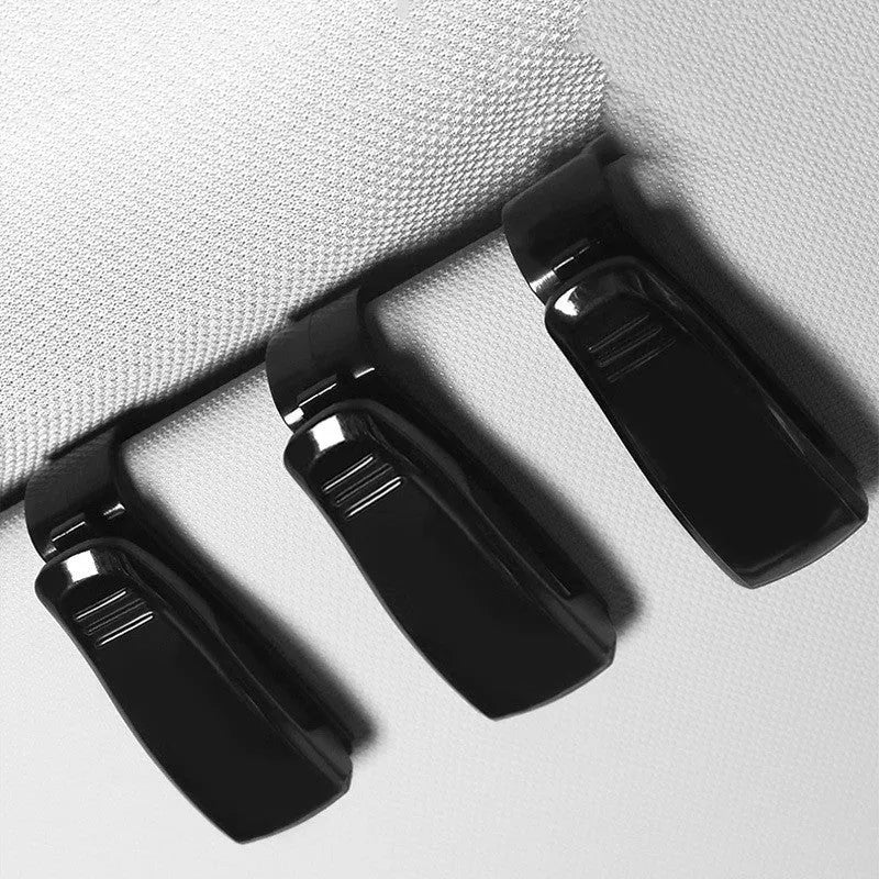Black plastic car sun visor clip for holding sunglasses, tickets and ID cards.