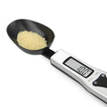 Stainless steel smart digital measuring spoon with a black LCD display showing weight measurement.