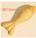 Yellow catnip fish plush chew toy for cats lying on a wooden floor.