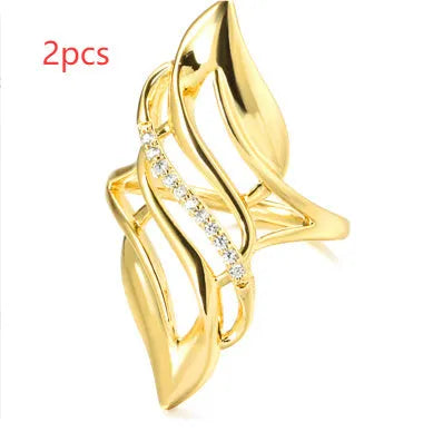 Gold-colour women's ring with exaggerated curved design and zircon crystal detail on a copper band.