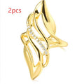 Gold-colour women's ring with exaggerated curved design and zircon crystal detail on a copper band.