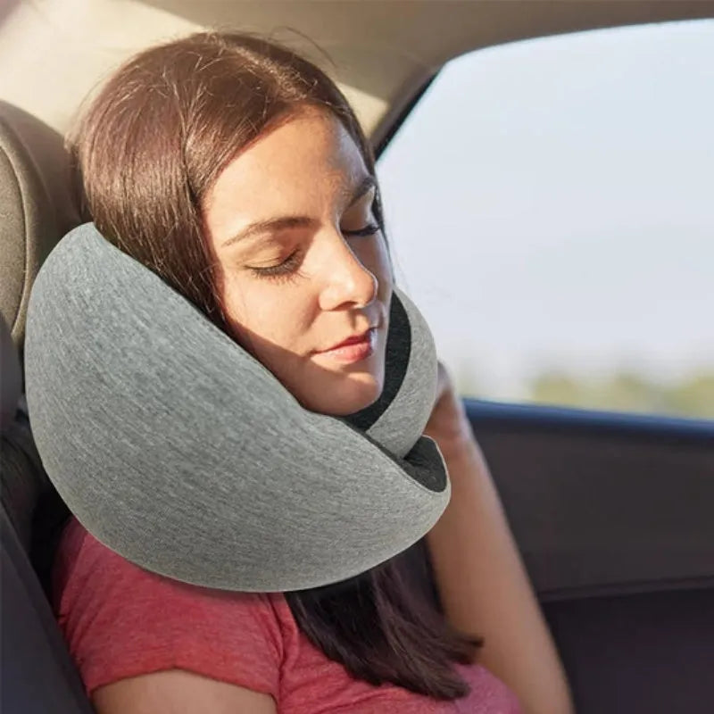 U-shaped navy blue travel neck pillow with memory foam, shown rolled up next to its carry bag.