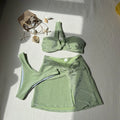 Light green one-shoulder tube top swimsuit set with high-waisted bottoms and matching skirt laid flat.