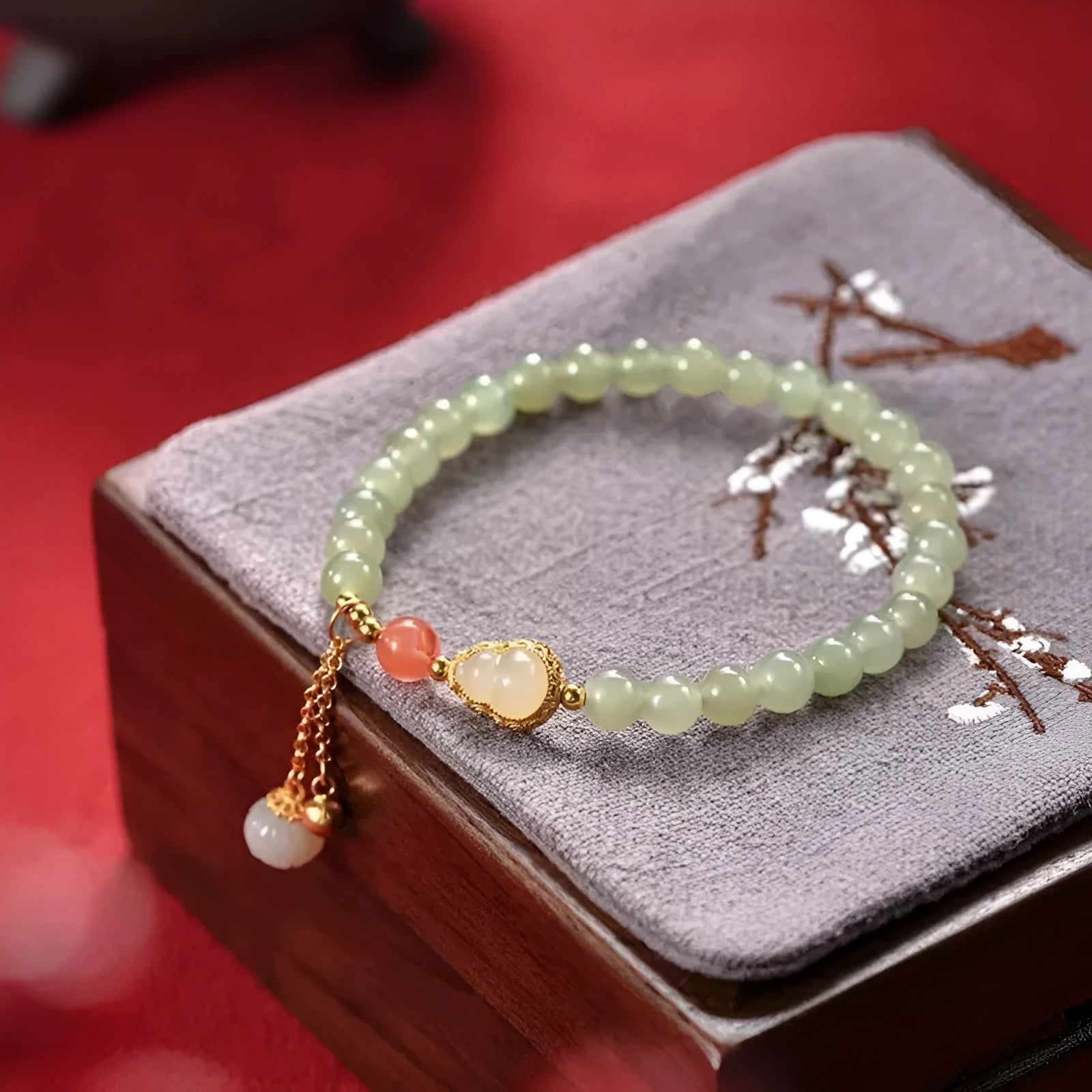 Jade women's bracelet with gold-plated fu character and a central gourd charm on wrist.