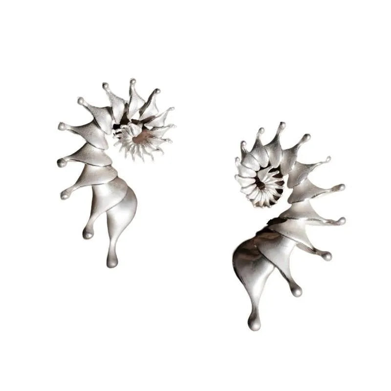 A pair of matte finish conch-coloured alloy stud earrings with a three-dimensional irregular shape.