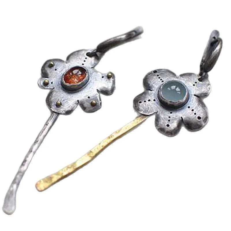 A pair of long retro earrings with asymmetric geometric flower shapes in a two-tone electroplated finish.