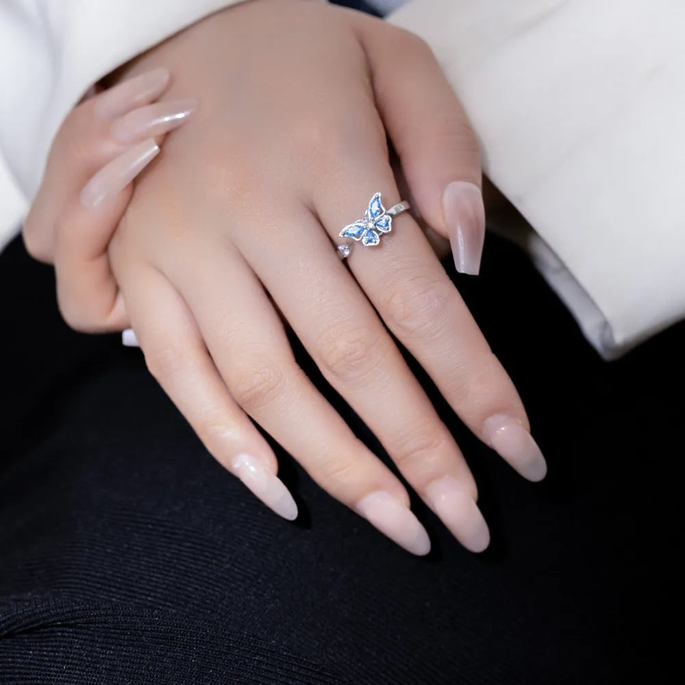 Butterfly adjustable ring with electroplated white gold finish and blue diamond accent on copper base