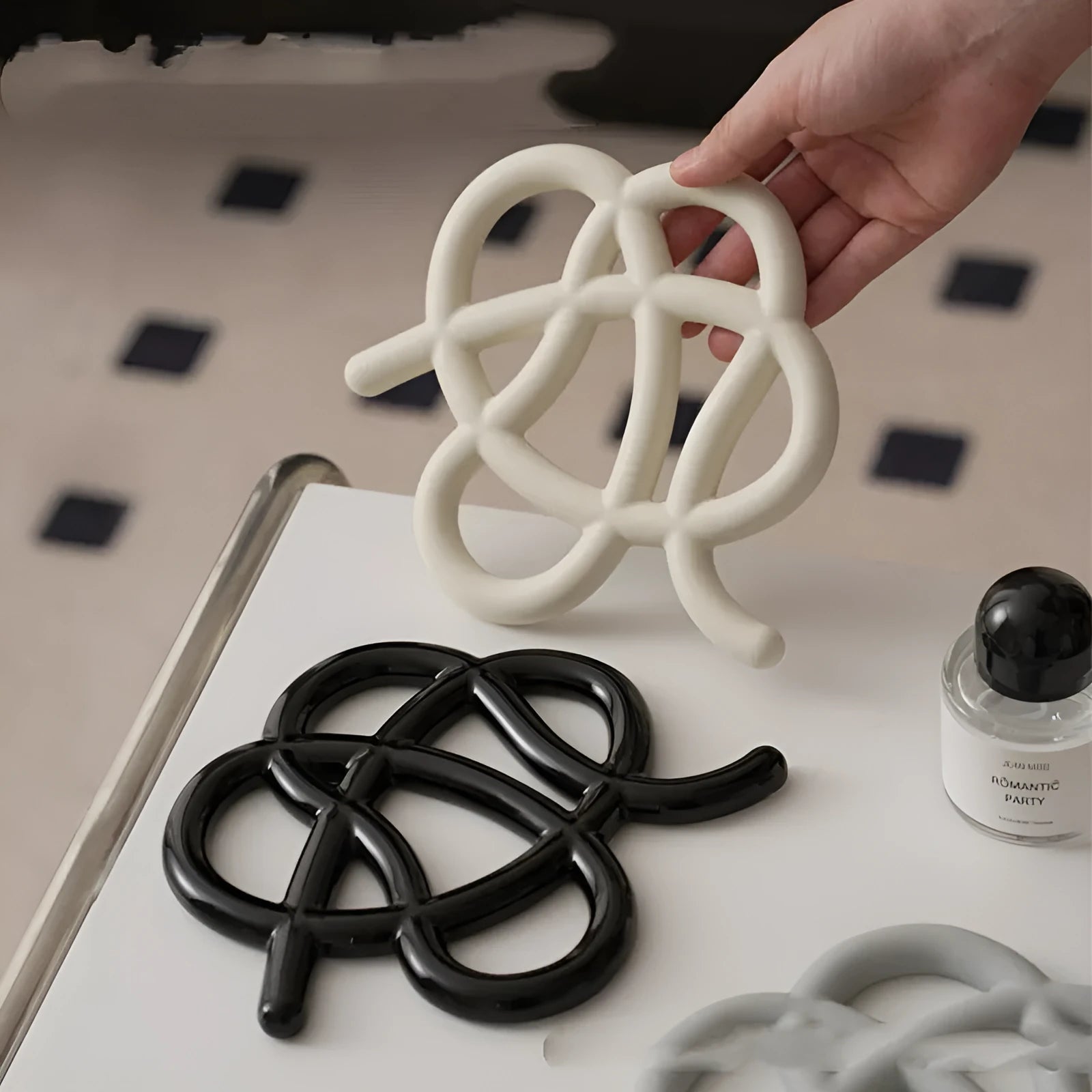 A solid colour ceramic heat proof mat with an irregular shape on a dining table.
