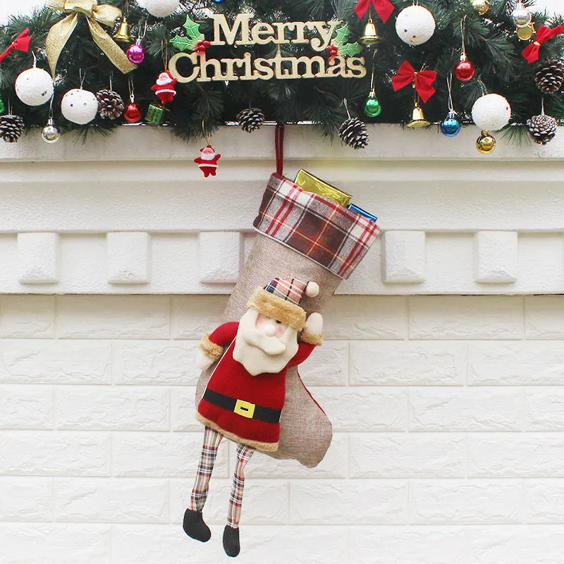 Three Christmas sock gift bags with old man, snowman, and elk designs on a light background