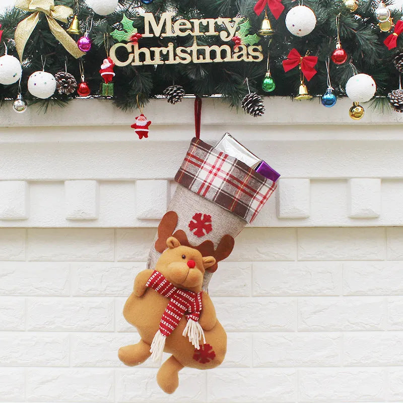 Three Christmas sock gift bags with old man, snowman, and elk designs on a light background