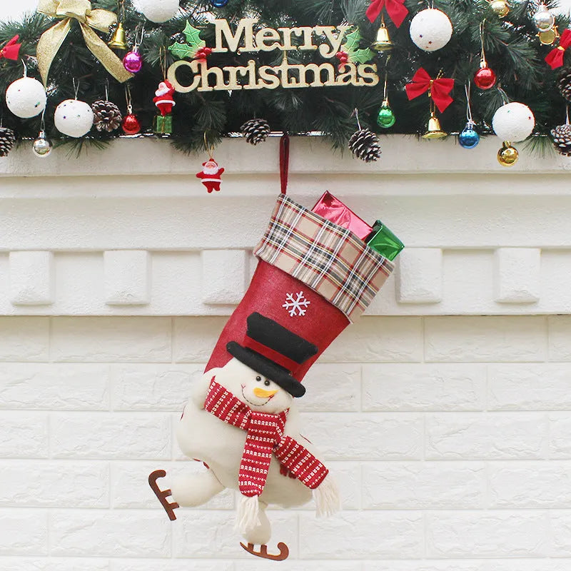 Three Christmas sock gift bags with old man, snowman, and elk designs on a light background
