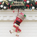 Three Christmas sock gift bags with old man, snowman, and elk designs on a light background