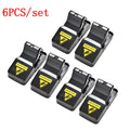 Set of six black plastic snapping mousetraps showing size and smooth surface