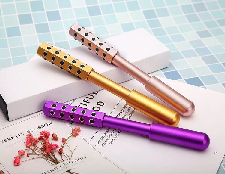 Handheld germanium particles facial massage roller in purple colour on a white background