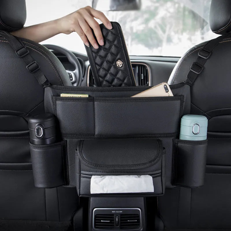 Black leather car seat hanging storage organiser for tissue boxes, shown between vehicle front seats.