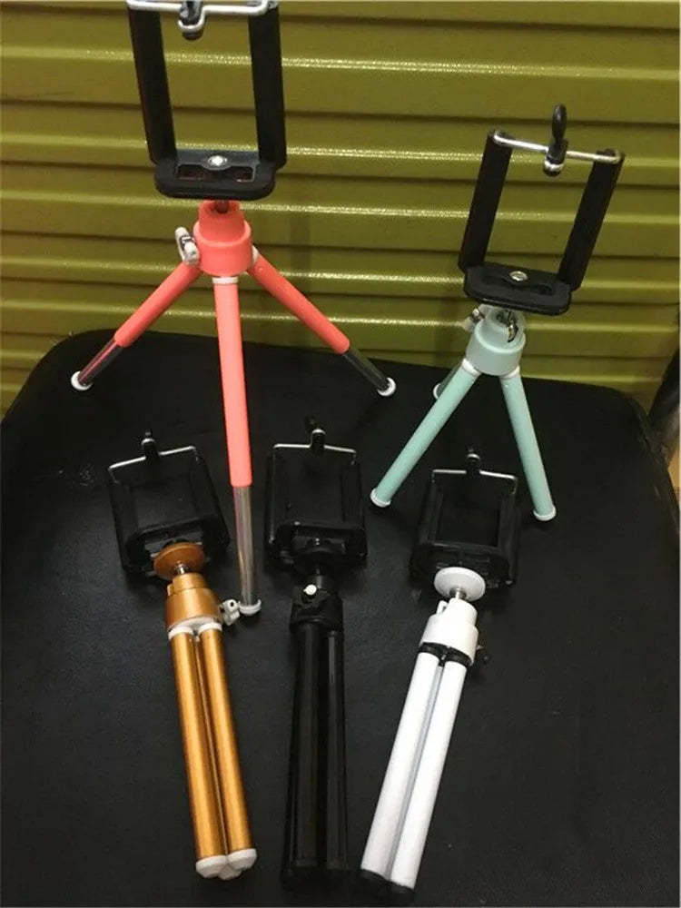 Black metal desktop phone holder with two-section adjustable bracket holding smartphone