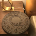 Square 25cm 10W fast wireless phone charger with glowing magic array pattern in black on a desk