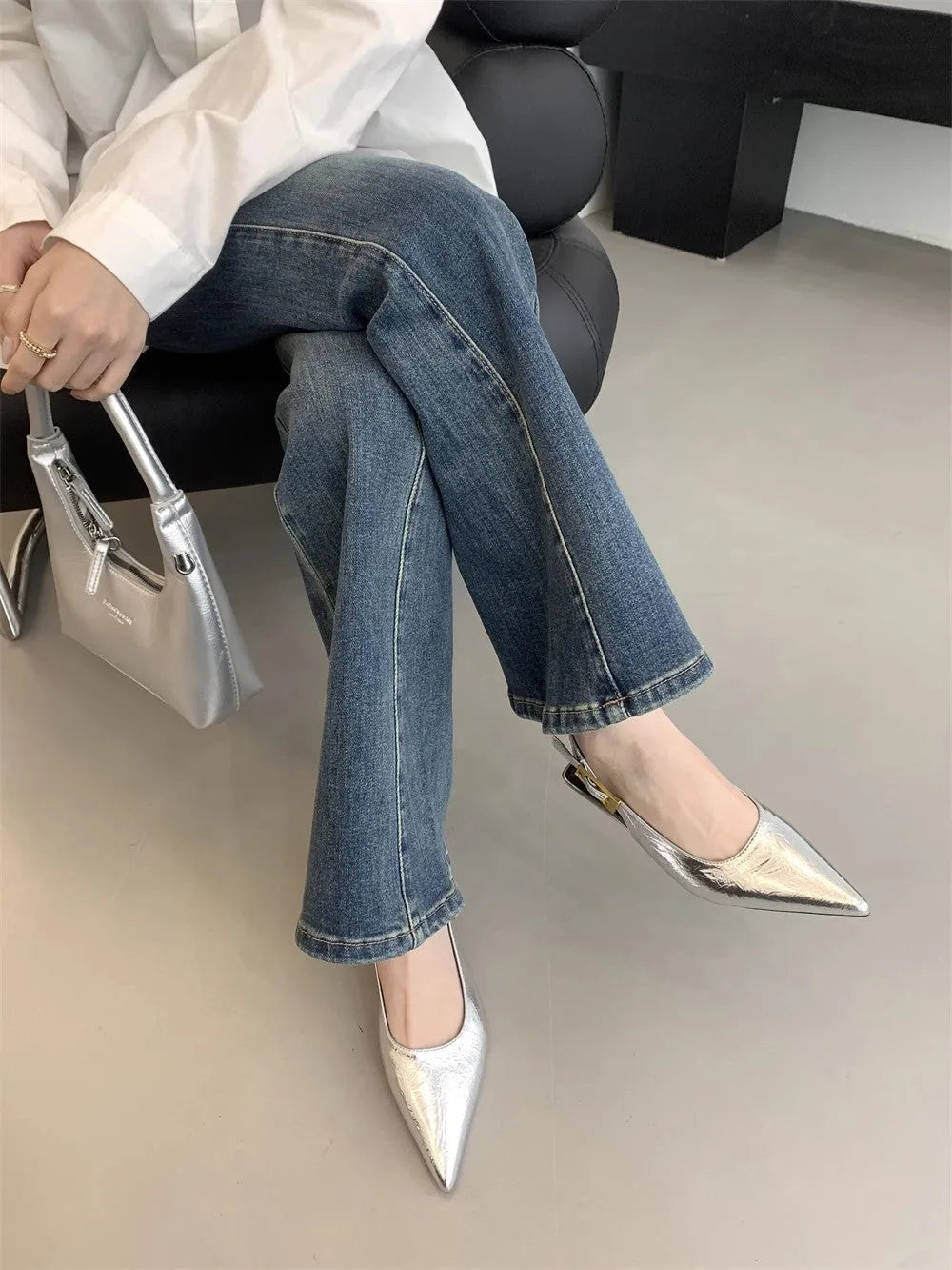 Thin low heel strap pointed leather shoes in black colour showing ankle strap and rubber sole