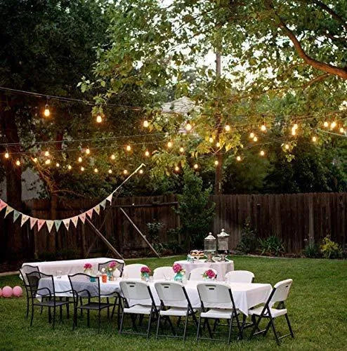 Waterproof solar-powered LED string lights hanging outdoors on a garden fence.