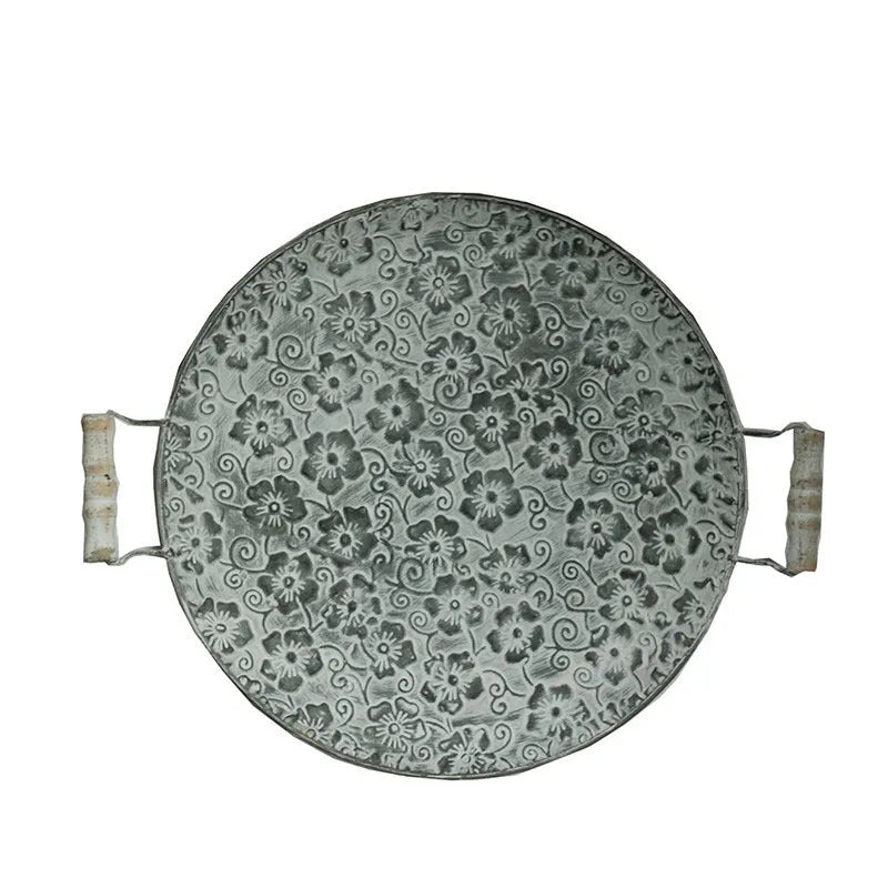 Black round wrought iron belt storage tray shown in two sizes on a wooden surface.