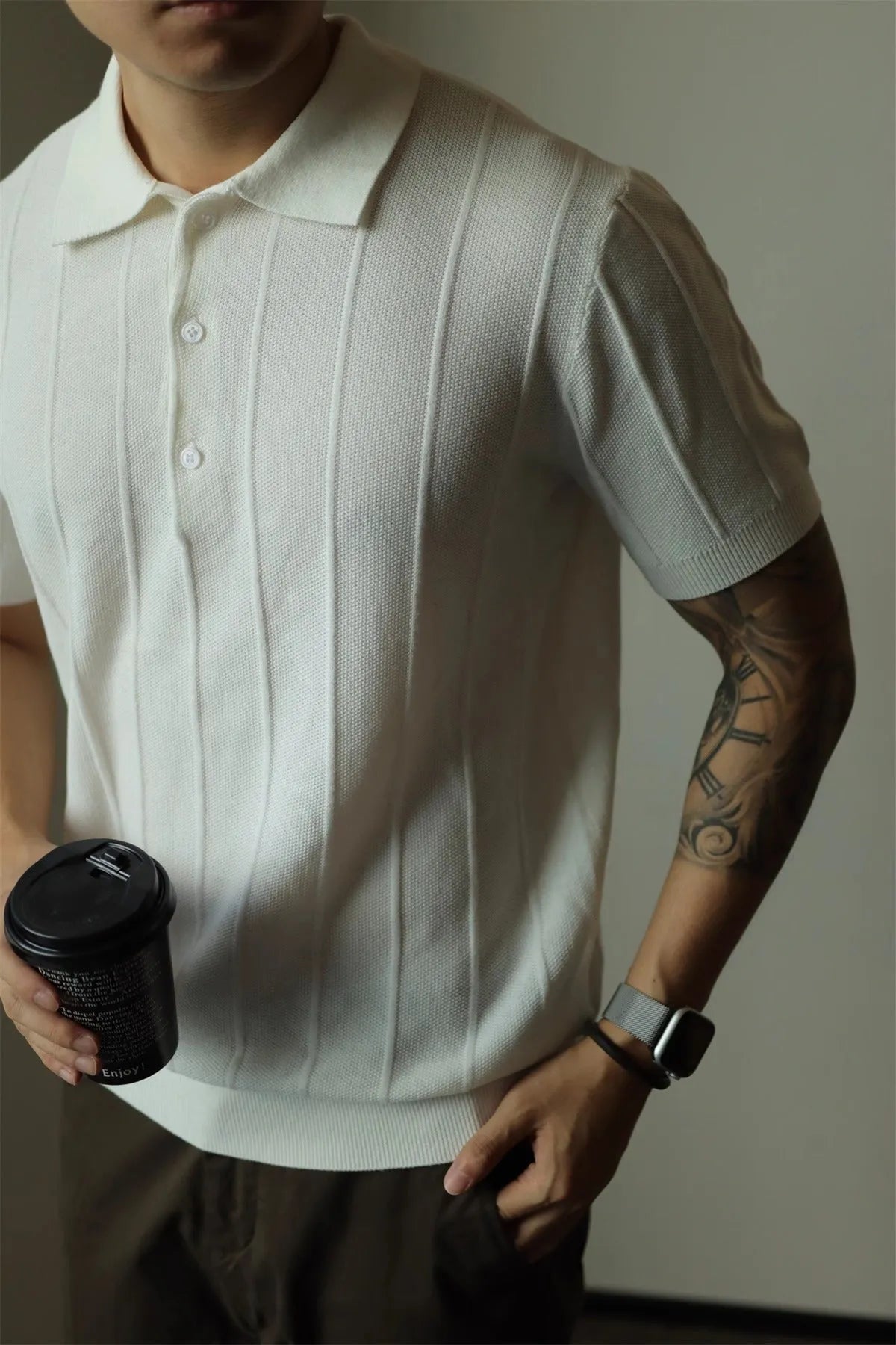 A man's loose-fit solid colour polyester pullover t-shirt on a hanger, shown in black and white colour options.