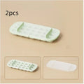 Food-grade high-capacity ice cube tray grid in blue with included ice shovel stored in dedicated slot.