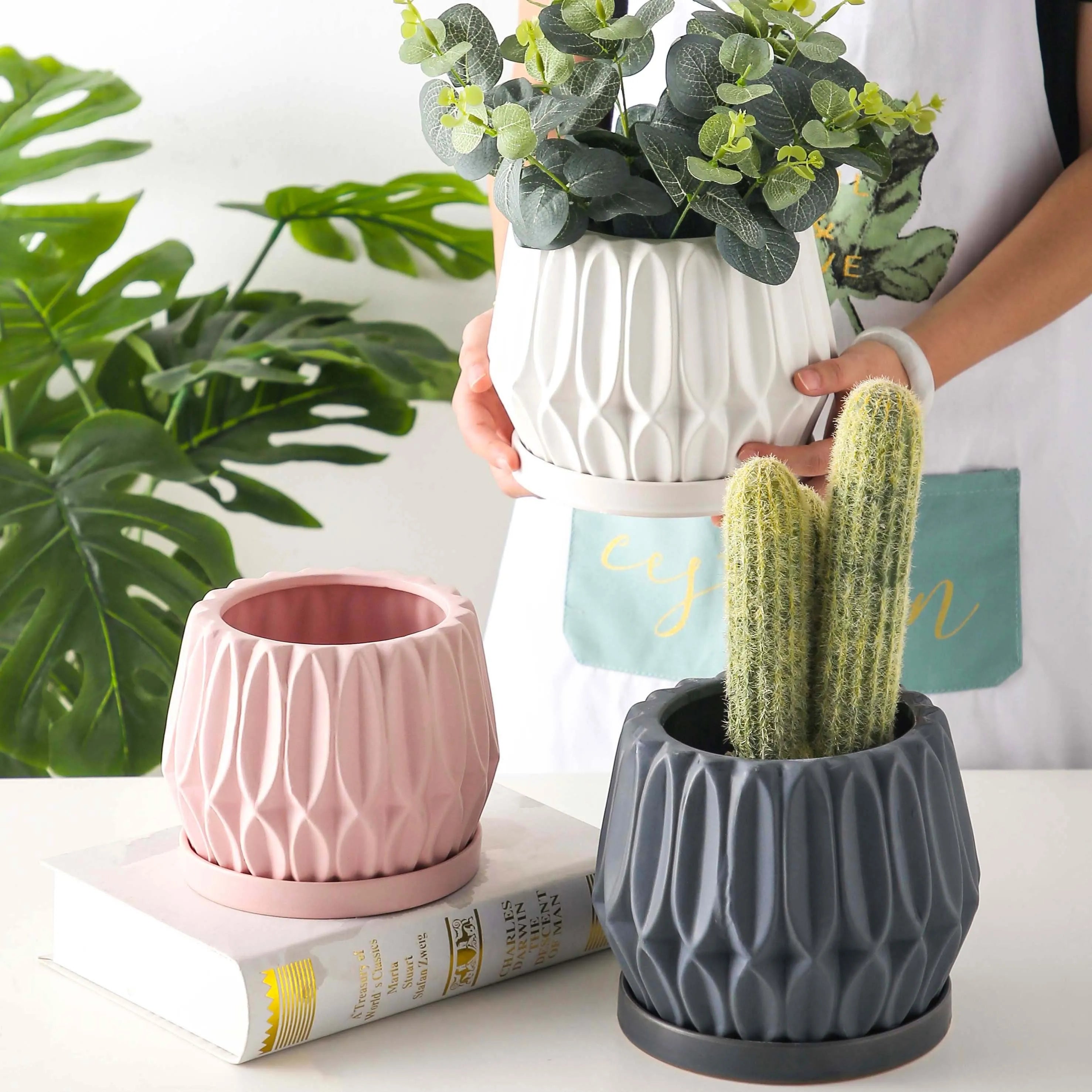 A simple grey ceramic flowerpot, medium-sized, for tabletop or floor plants.