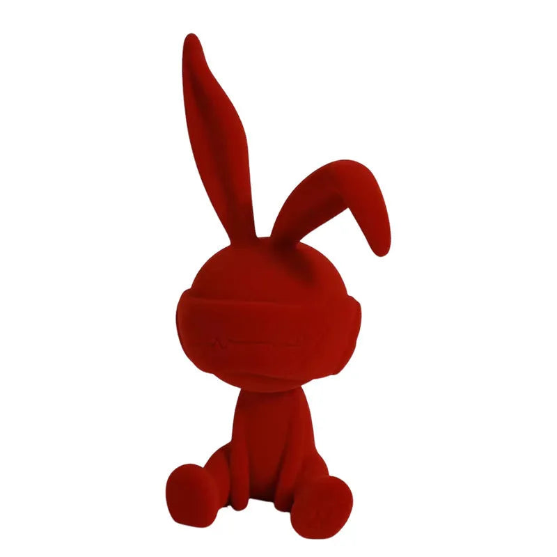 Small green resin suede blindfold rabbit table ornament on a wooden surface